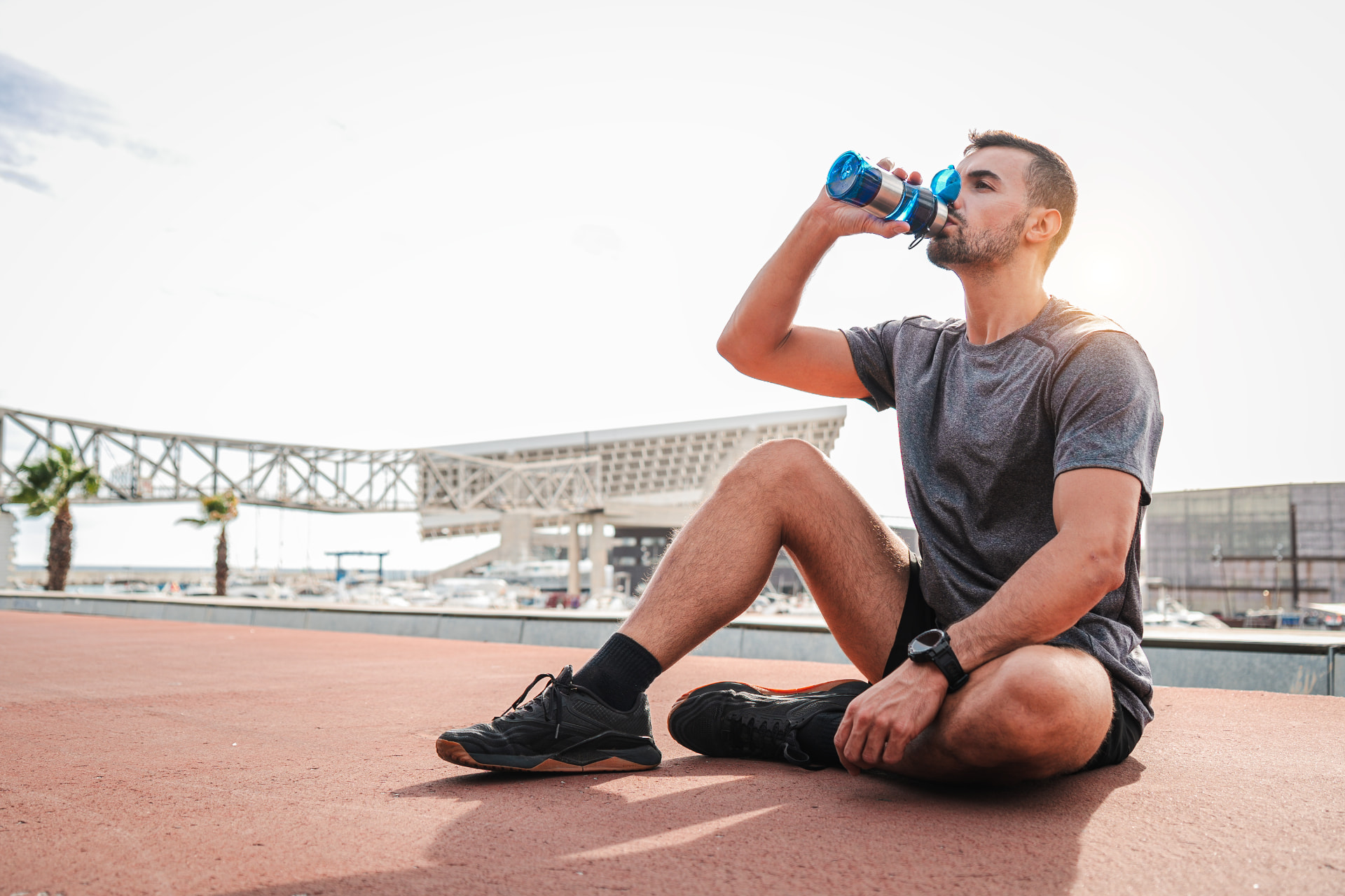 Man resting and hydrating after a workout, recovered and energized